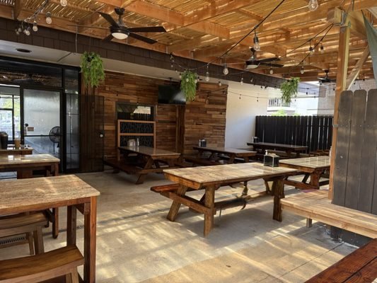 The new Kona cafe covered patio with reclaimed wood tables and string lights