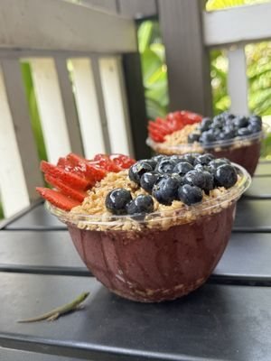 Acai bowl topped with berries and granola, drizzled with local honey