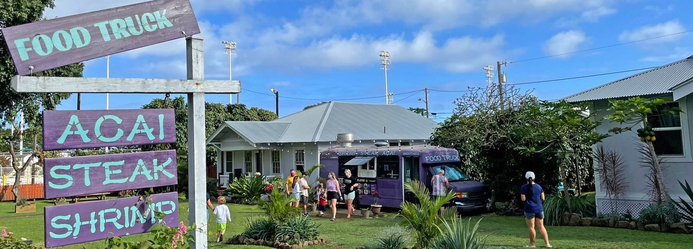 The original purple Aloha Mix food truck in Naalehu with hand-painted plank signs reading Food Truck, Acai, Steak, Shrimp