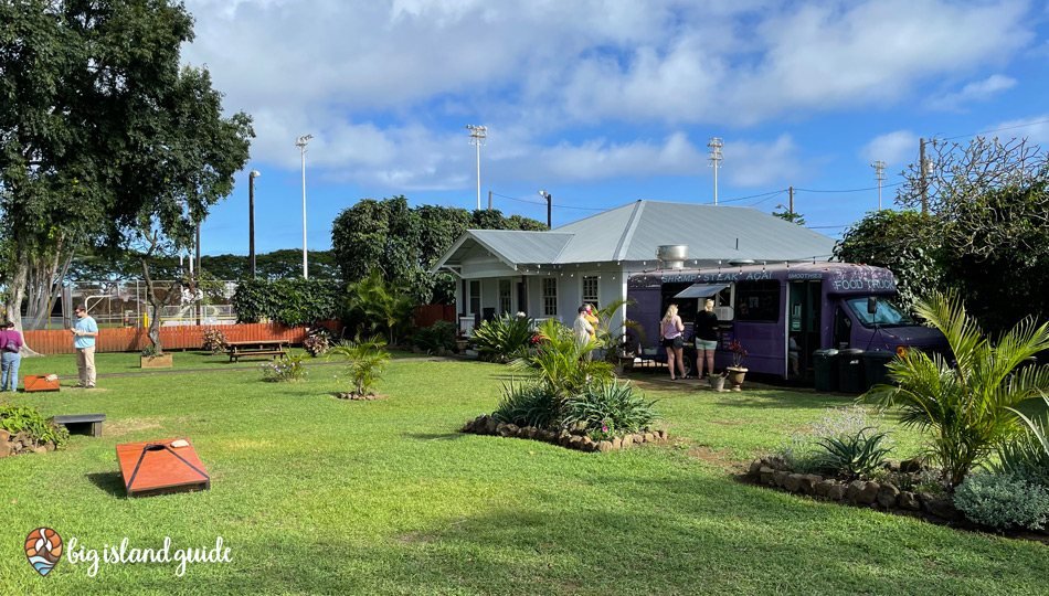 The Naalehu food truck in a grassy yard with picnic tables and string lights